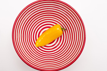 fresh yellow chili pepper in red and white spiral bowl