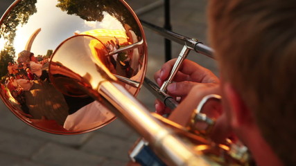 man playing trumpet music sitting on sunny summer day