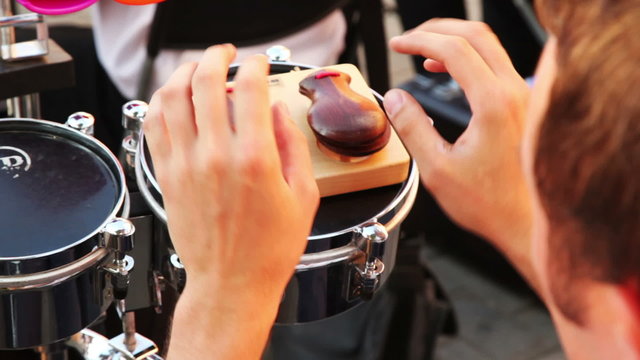 man of brass band plays castanets sitting on summer day