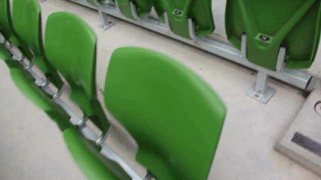 Green benches of the stadium teraccing, moving camera