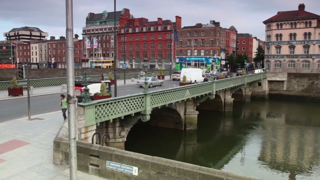 Cars and passers-by bridge over river