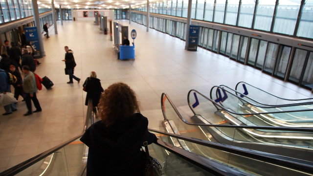 woman falls down on moving escalator to exit of airport