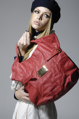 Fashion girl with red big bag posing on gray background