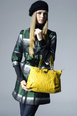 Fashion girl with bag posing in the studio