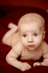 Kid on the burgundy bedspread