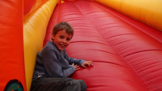 boy drives off sitting  with inflatable rubber slides