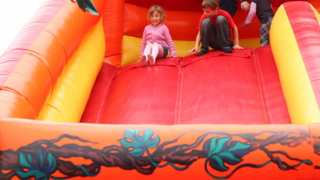 boy and girl drive off with inflatable rubber slides