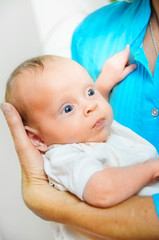 Happy cute infant lying on his grandmother hands