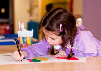 Girl drawing in kindergarten