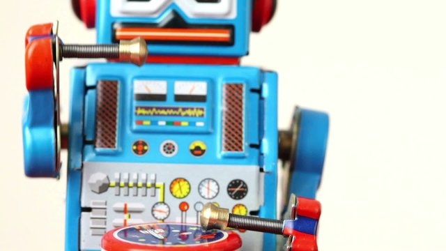 closeup of blue clockwork robot make steps on table, beats drum