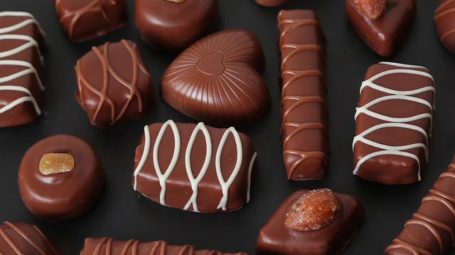 closeup of sweet chocolates on black turn around