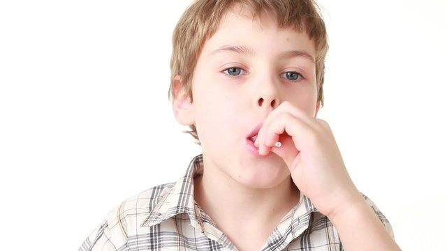The boy eating yellow chupa chups candy and laughing