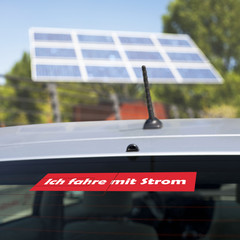 Elektroauto vor einem Solarpanel