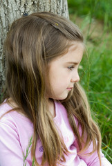 Worried little girl on grass