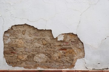 Stone wall with peeling plaster