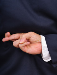 Businessman with fingers crossed behind his back