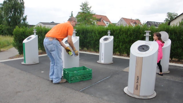 Mann mit Kind am Glascontainer