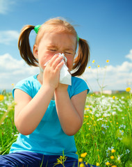 Little girl is blowing her nose