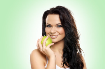 Portrait of a young and attractive woman holding a green apple