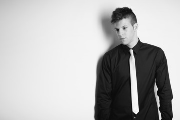 Portrait of young man leaning against a wall and thinking