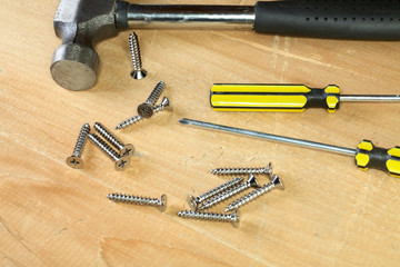 Hammer screw-driver screws on a  board