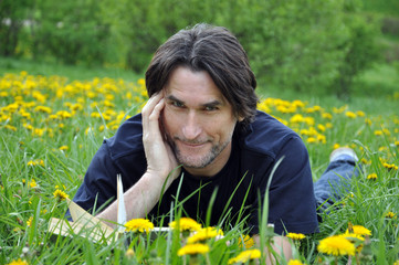 A man reads a book in the park