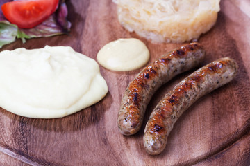zwei Bratwürste auf einem Holzbrett