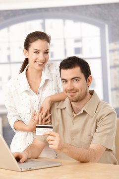 Happy couple enjoying online shopping smiling