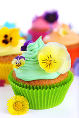 Easter cupcakes on white background decorated with fresh violets