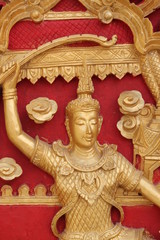 Thai art carving and painting on wooden window of temple