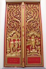 Thai art carving and painting on wooden window of temple