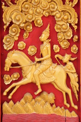 Thai art carving and painting on wooden window of temple