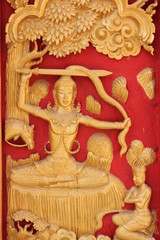 Thai art carving and painting on wooden window of temple