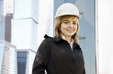 Female construction worker in hard hat on city background