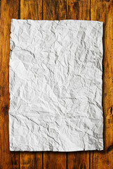 Crumpled paper on wood background