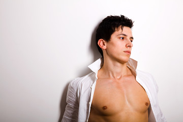Portrait of young man leaning against a wall and thinking