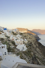 Pastel colored houses over the caldera in Oia, Greece