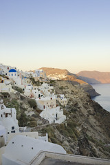 Naklejka premium Pastel colored houses over the caldera in Oia, Greece