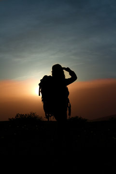 girl with a backpack in the mountains at sunset