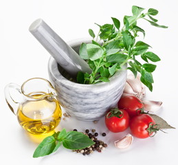 Mortar with pestle and basil herbs and olive oil.