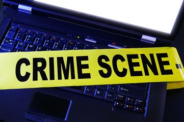 laptop with yellow crime scene tape across it