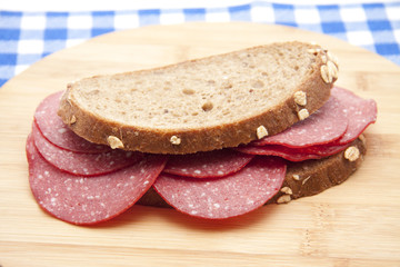 Brot mit Putensalami auf Holzteller
