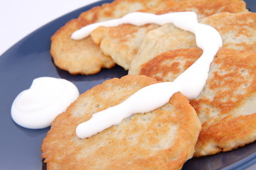 Potato pan cakes with cream on white background