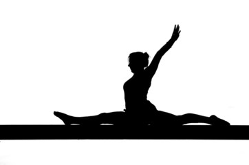 silhouette of female gymnast doing the splits on balance beam