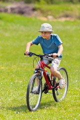 Boy riding a bicycle on grass field