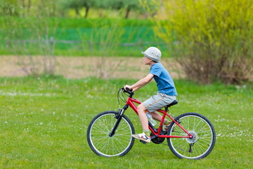 Fototapeta premium Boy with hat riding a bicycle