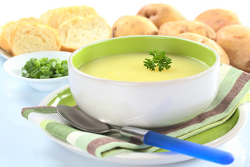 Fresh potato cream soup garnished with a parsley leaf