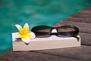 Livre et lunettes de soleil, piscine
