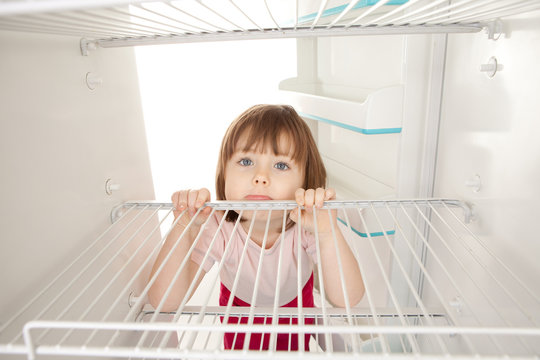 Girl looking in empty fridge