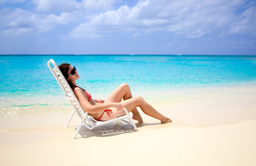 Fototapeta na wymiar woman sitting in a beach chair in the caribbean